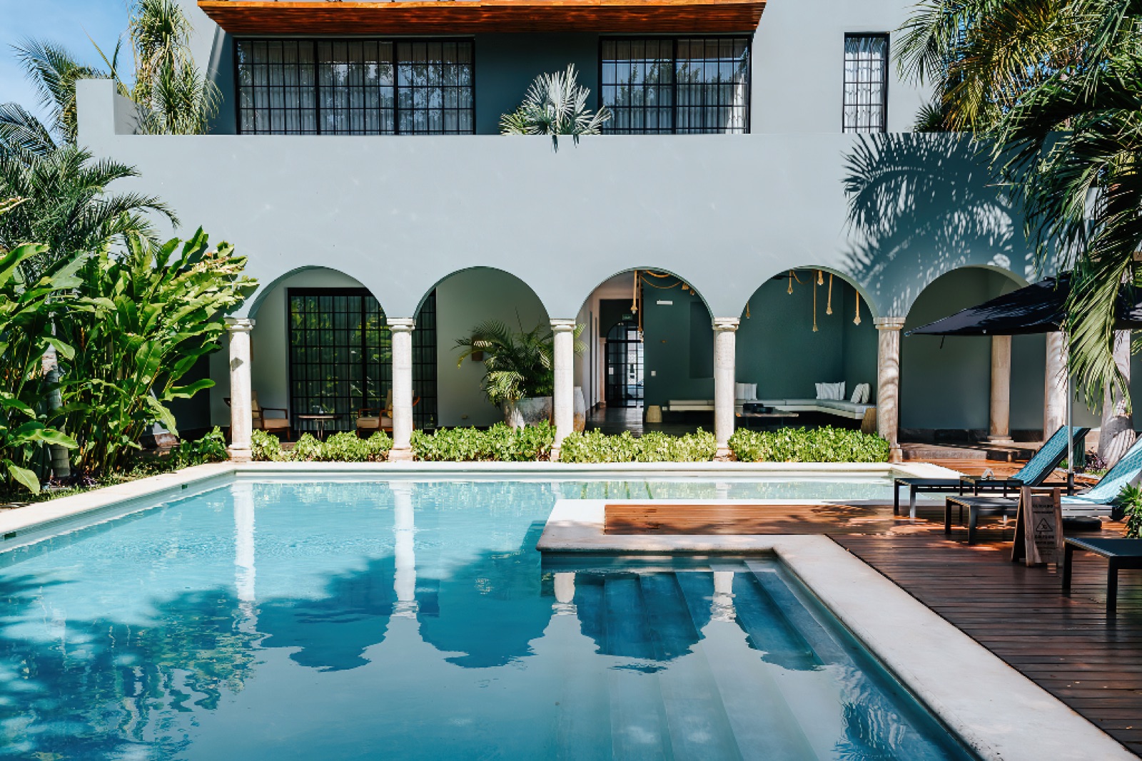 Piscina del Hotel Antelar rodeada de arcos coloniales y jardines tropicales